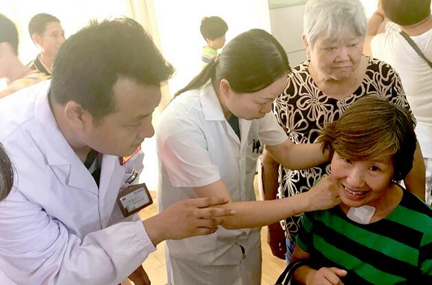 湖北省武汉市中西医结合医院医务人员为聋哑患者进行穴位贴敷治疗