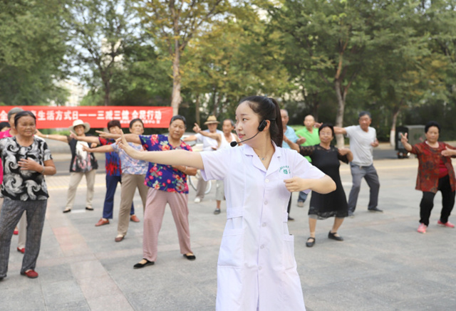 山东省邹平县黄山社区医务人员指导居民练习八段锦